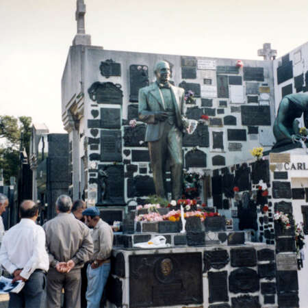 <p>A group of admirers at the tomb of Carlos Gardel, the great tango singer who died in a plane crash in 1935. The men gathered regularly at the grave in Chacarita Cemetery, trading stories, lyrics, and photos. They all shared the view that with each passing year, Gardel sings better.</p>