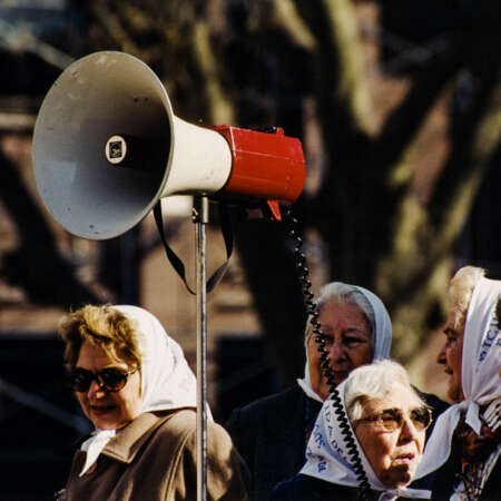 <p>Some of the Madres de la Plaza de Mayo prepare to air their calls for justice directly at the presidential palace in Buenos Aires. Their intense expressions match the determination they have shown in their decades-long struggle for accountability.</p>
