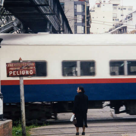 <p>A woman waits at a level crossing in Buenos Aires.</p>