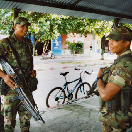 <p>Two soldiers guard a street corner in central Tame, a town in Colombia's war-ravaged Arauca department. Their presence was part of an attempt to hold the town after it was reclaimed from guerrillas. <br /></p><p>They are laughing at a joke my colleague made about the relative size of their weapons – indeed, the US M60 carried by the soldier at left is a hefty machine gun often fired by a team of two or three gunners, while the soldier at right carries a more standard-issue Galil, an Israeli derivative of the infamous Soviet/Russian AK-47. </p>