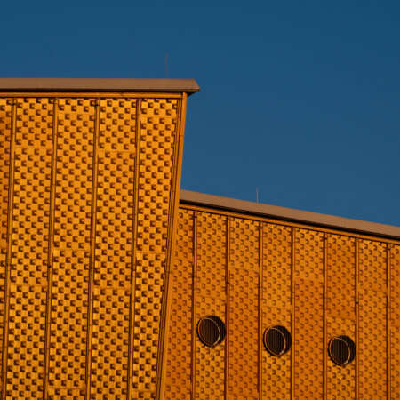<p>A detail of the golden cladding and angular roofline of the Kammermusiksaal (chamber music hall) at the Philharmonie complex in Berlin.</p>