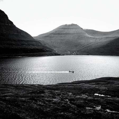 <p>A boat navigates the Funningsfjørður, a deep fjord that cuts through the island of Eysturoy.</p>