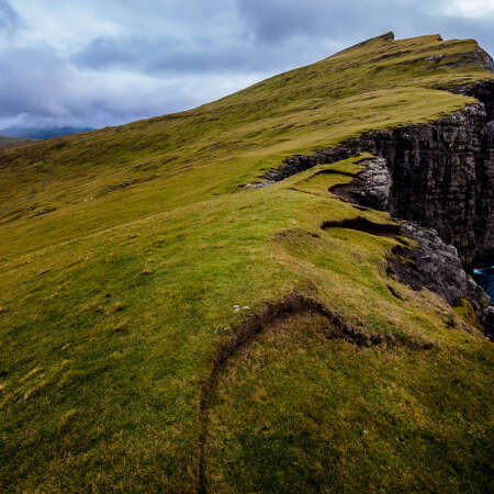 <p>The gentle slope toward a sheer drop at Sørvágsvatn.</p>