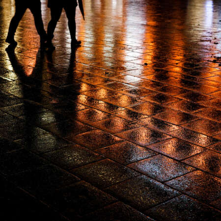 <p>A couple cut through a glistening Marienplatz, Munich.</p>