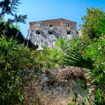 <p>An old house perches on an even older wall.</p>