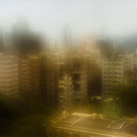 <p>A view over the rooftops of Kowloon, near the Hong Kong Observatory. The blur results from condensation on the lens due to a rapid transition from a climate-controlled interior to Hong Kong's humid exterior.</p>