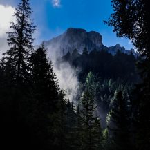 <p>Sunlight slices through forests beneath the Odle peaks.</p>