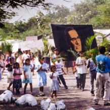 <p>In a rural Salvadoran cooperative, community members march under a banner of the slain Archbishop Oscar Romero, who dared to suggest that peasants like these might deserve an earthly bounty in addition to promises of posthumous salvation. For this heresy, he was assassinated by death squads linked to the Salvadoran establishment – a fate that awaited many of his flock.</p>
