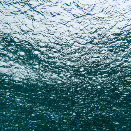 <p>Shot from beneath, raindrops ping the surface of the sea just off the sacred island of Jaco.</p>