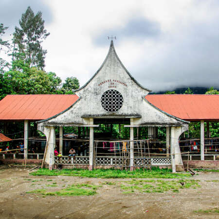 <p>A quiet afternoon at the market in the highland town of Ossu.<br /></p>
<p>The rustic structure features a functional vaulted roof covering the main trading area (useful given the torrential rainfall in the country) with a facade that mixes shapes from vernacular local architecture with a tinge of art deco, fashionable with the then-colonial ruler.</p>
